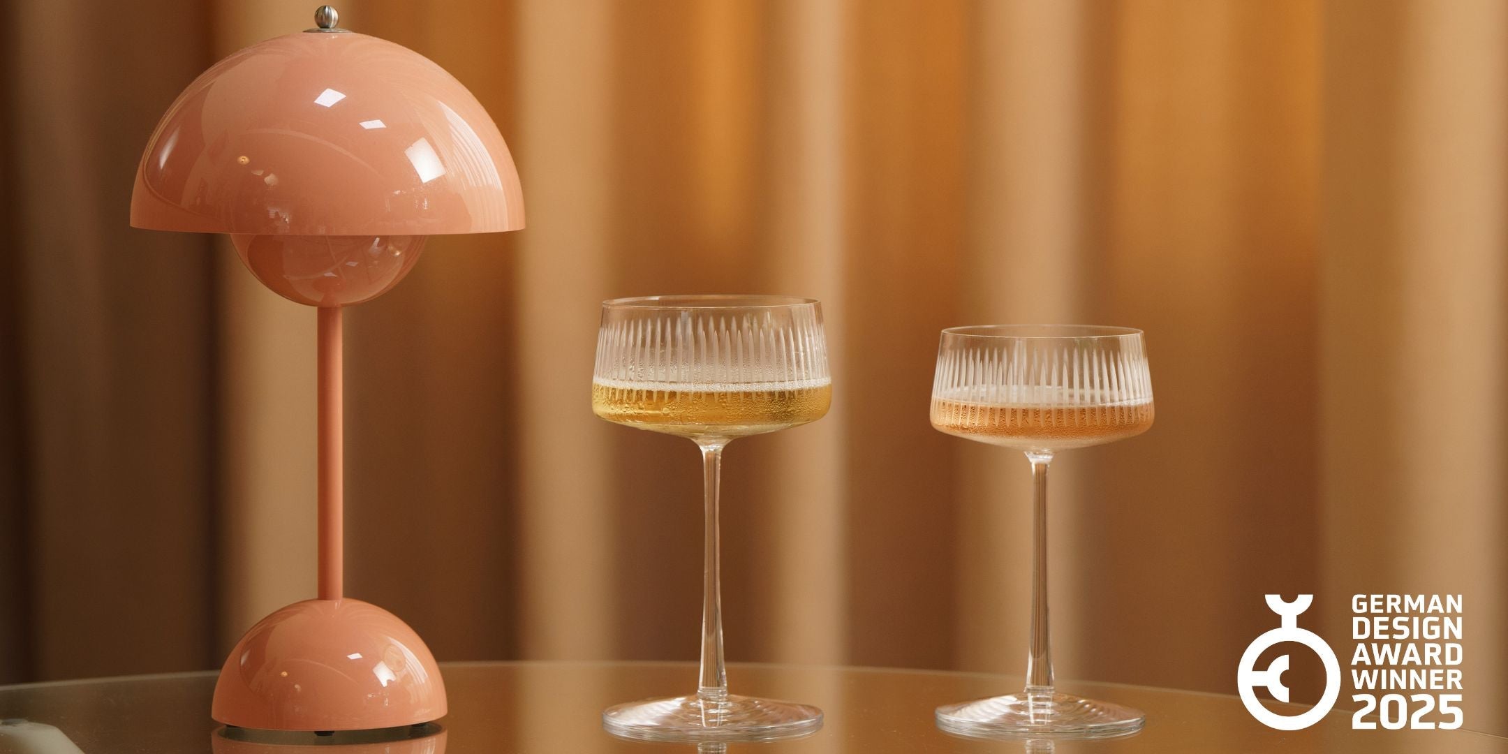 Die Soho Gläserkollektion mit eleganten Cocktailgläsern und einer stilvollen Lampe auf einem Tisch