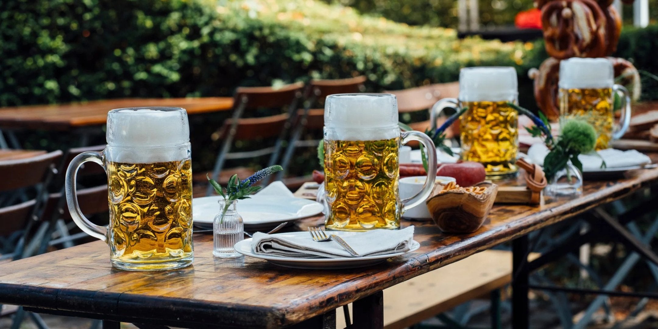 Fröhliche Bierkrüge auf einem Tisch im Freien für gesellige Abende – Oberglas Bierkrüge kaufen