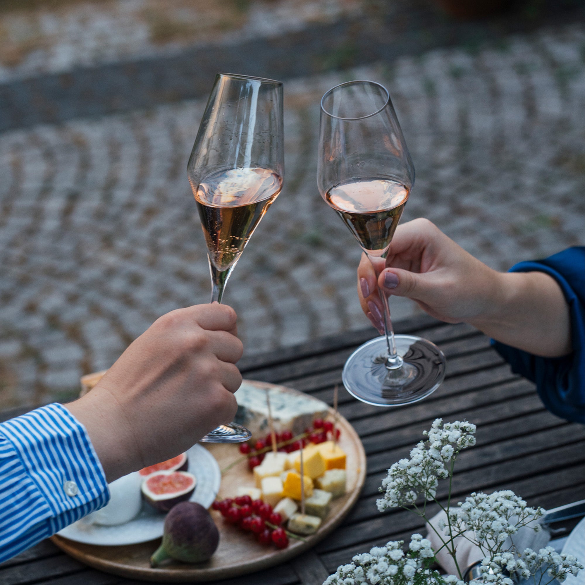 Champagnerkelch Quatrophil Set in Verwendung mit Snacks auf einem Tisch im Freien