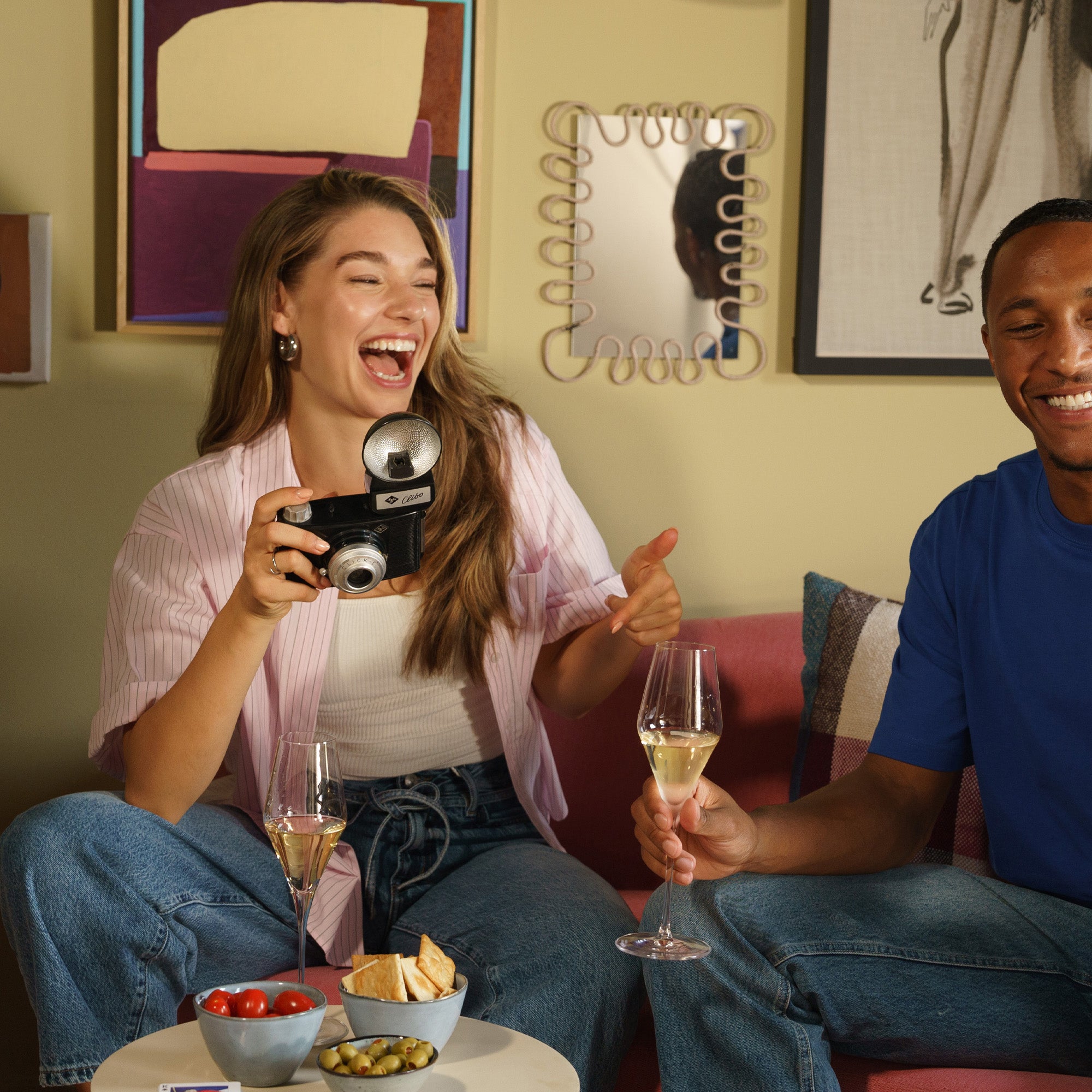 Zwei Personen entspannen mit Champagnerkelch Quatrophil Set und Snacks in modernen Raum