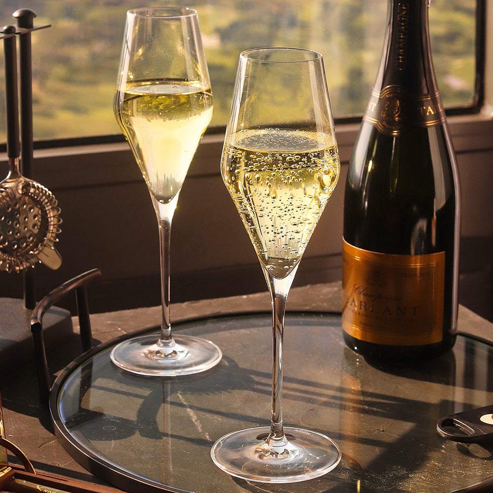 Stölzle Lausitz Champagnerkelch Quatrophil Set auf einem Tisch mit Sektflasche und Gläsern