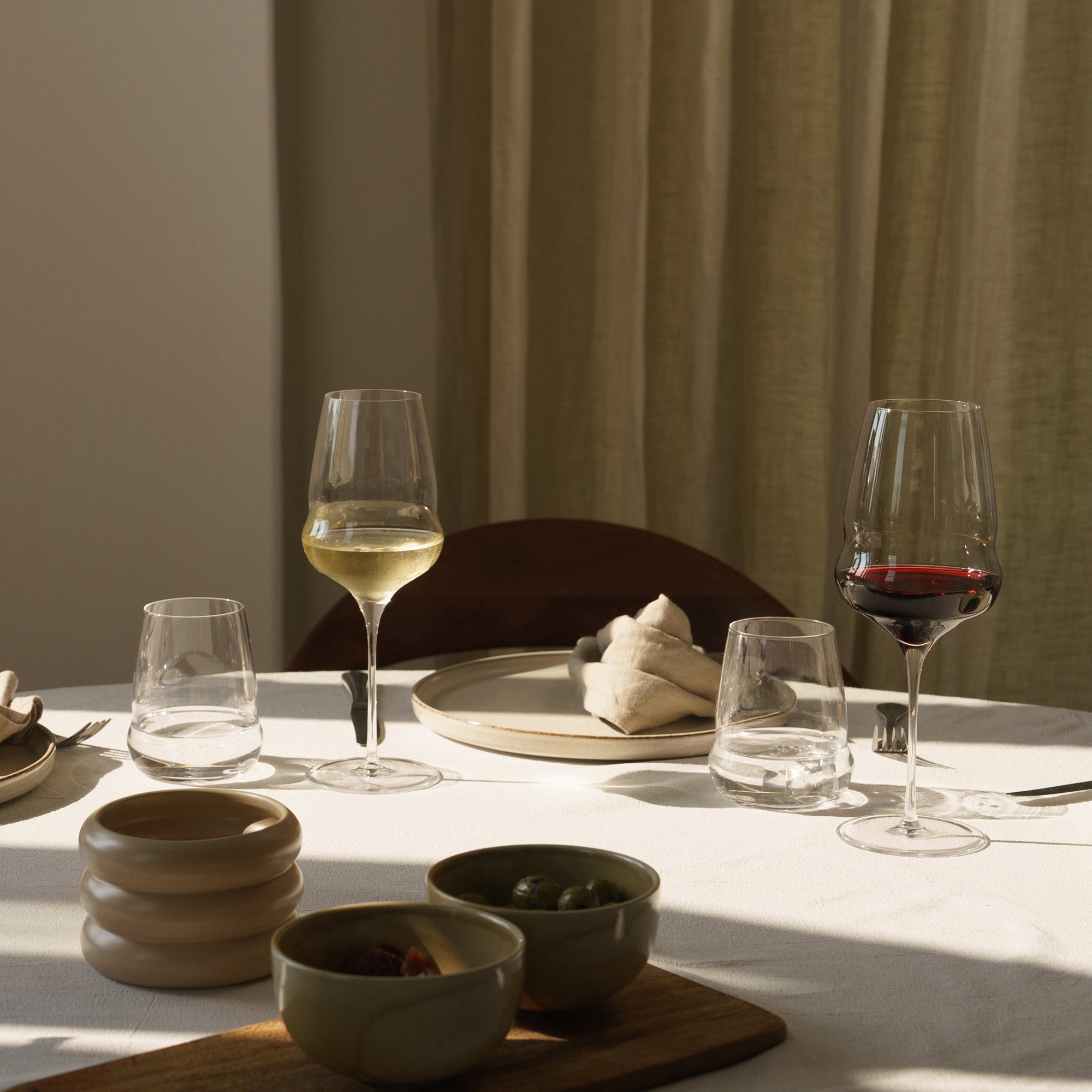 Stölzle Lausitz Cocoon Weißweinkelch in eleganter Umgebung mit Speisen und Gläsern auf dem Tisch