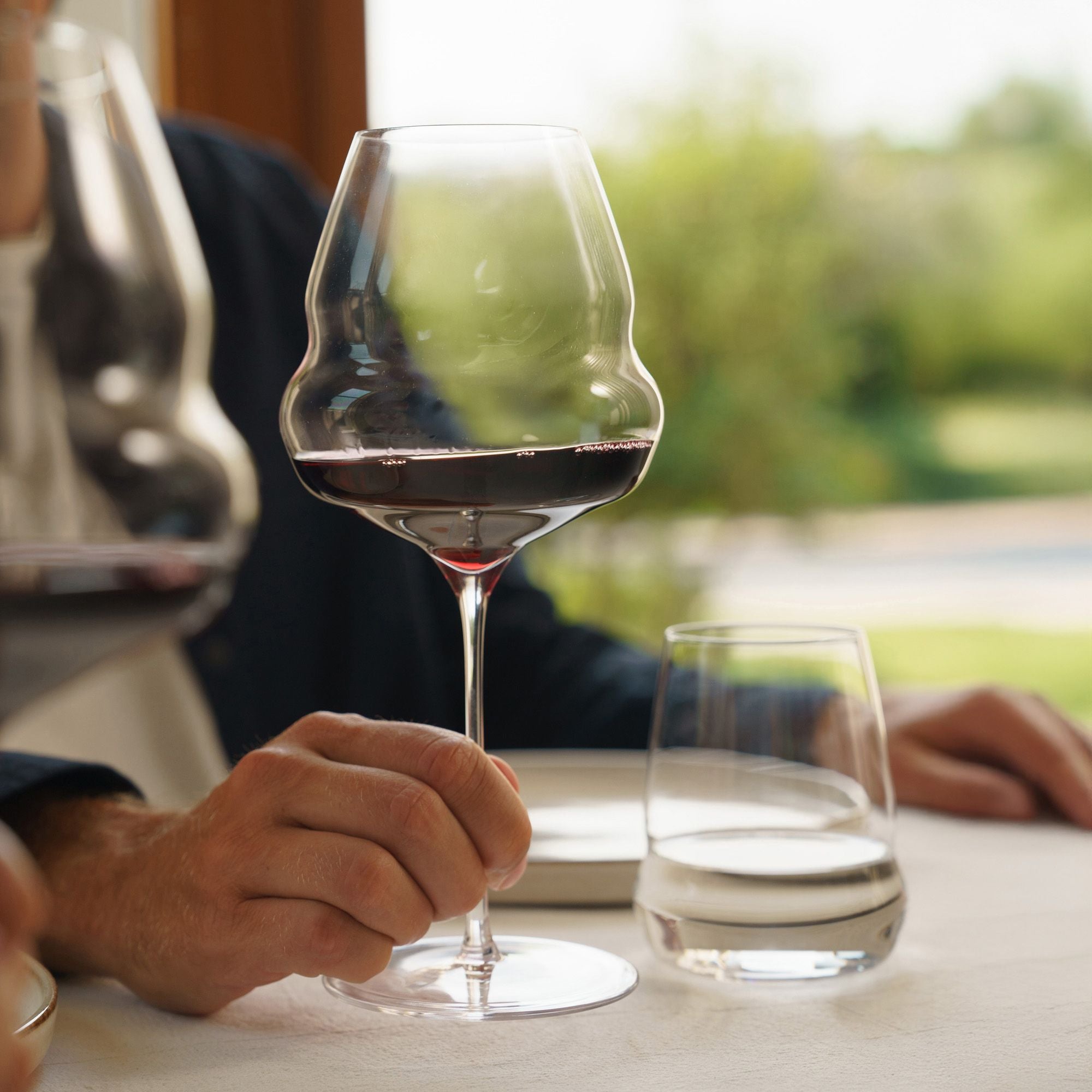 Edles Weinglas mit rotem Wein von Stölzle Lausitz edle Weingläser Made in Germany auf Tisch gehalten