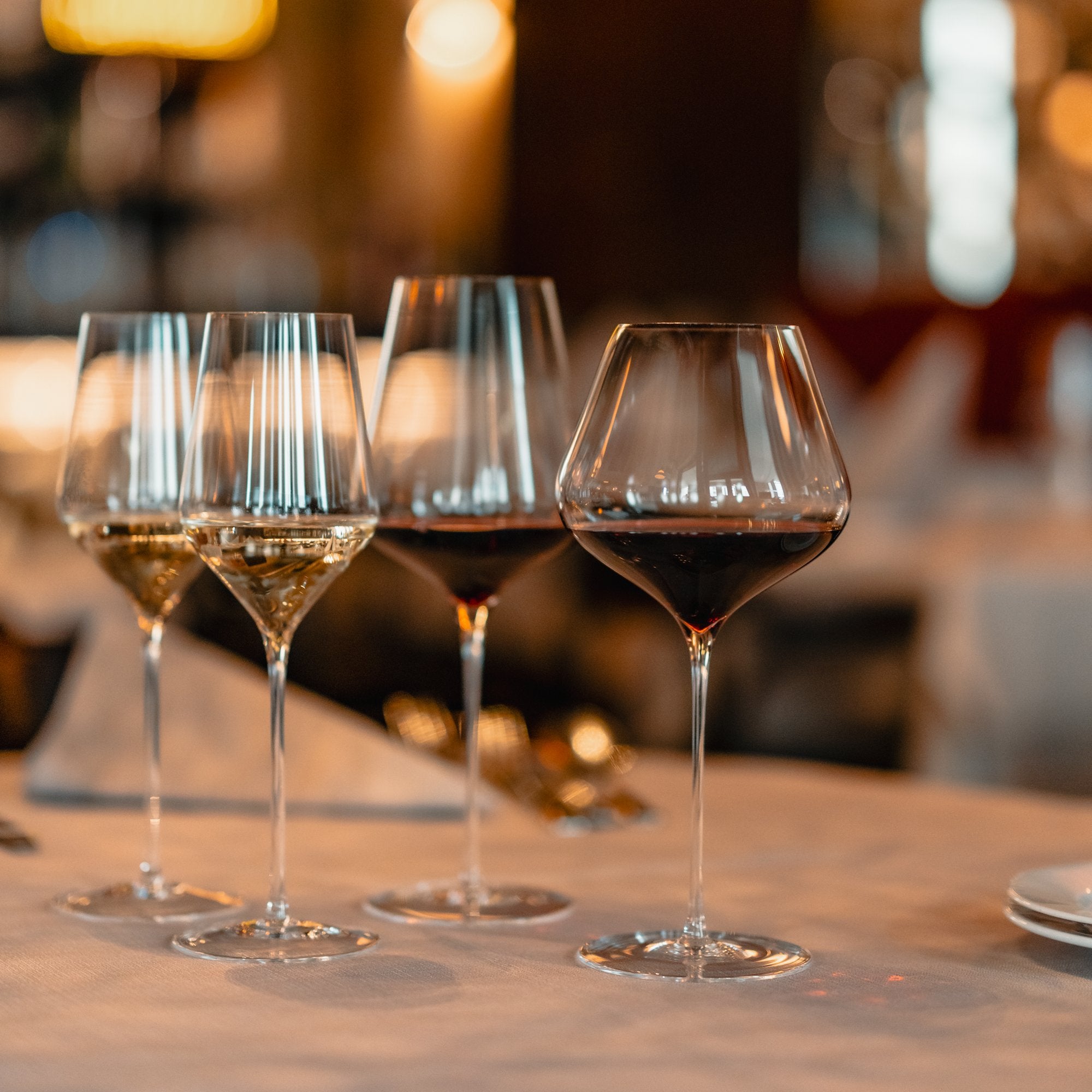 Vier exquisite Weingläser kaufen, perfekt für Weinliebhaber in einem eleganten Restaurant-Setting