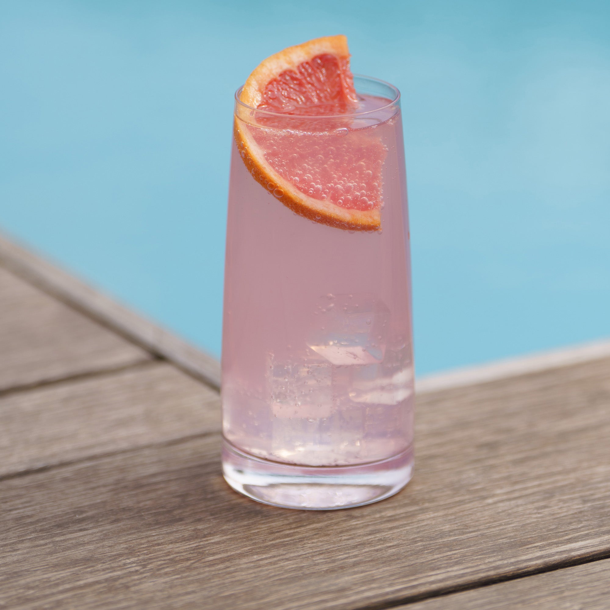 Stölzle Lausitz Highball Gläser Set mit erfrischendem Getränk und Grapefruitschale am Wasserpool