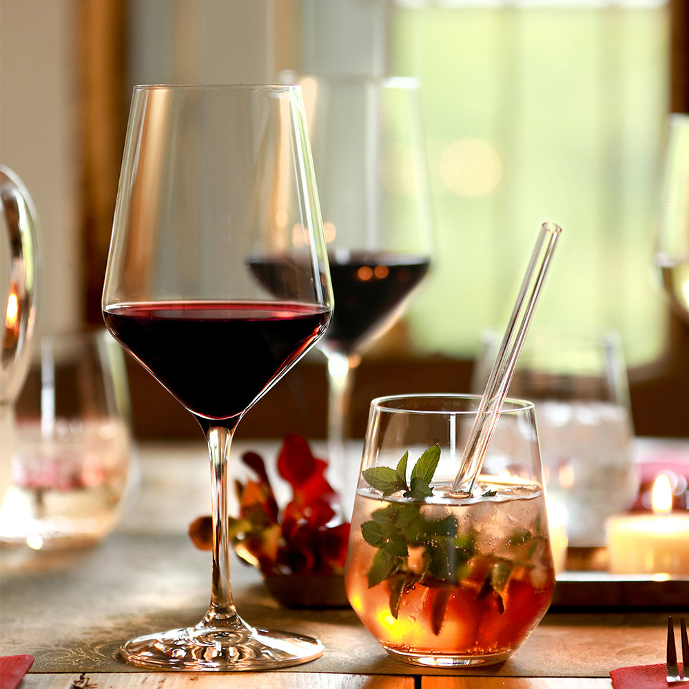 Hochwertige Bordeaux Kristallgläser mit Rotwein und Cocktail auf festlich gedecktem Tisch