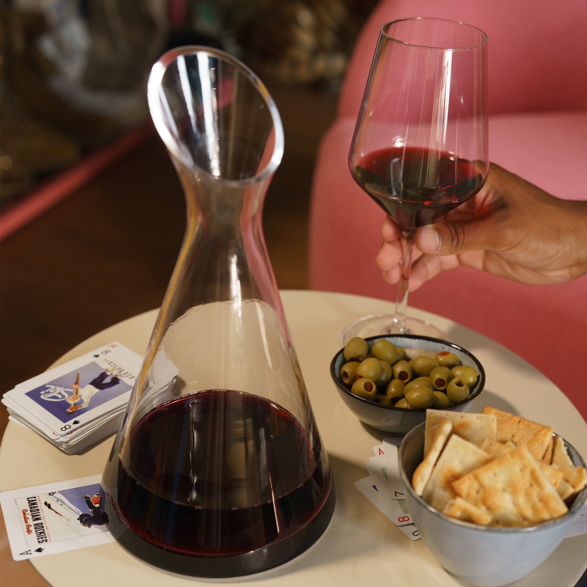 Hochwertige Bordeaux Kristallgläser mit Rotwein in einer eleganten Umgebung neben Oliven und Crackern