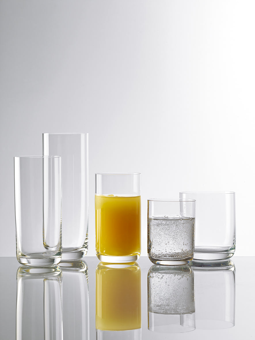 Set von hochwertigen Saftgläsern aus Glas in verschiedenen Höhen mit Getränken gefüllt