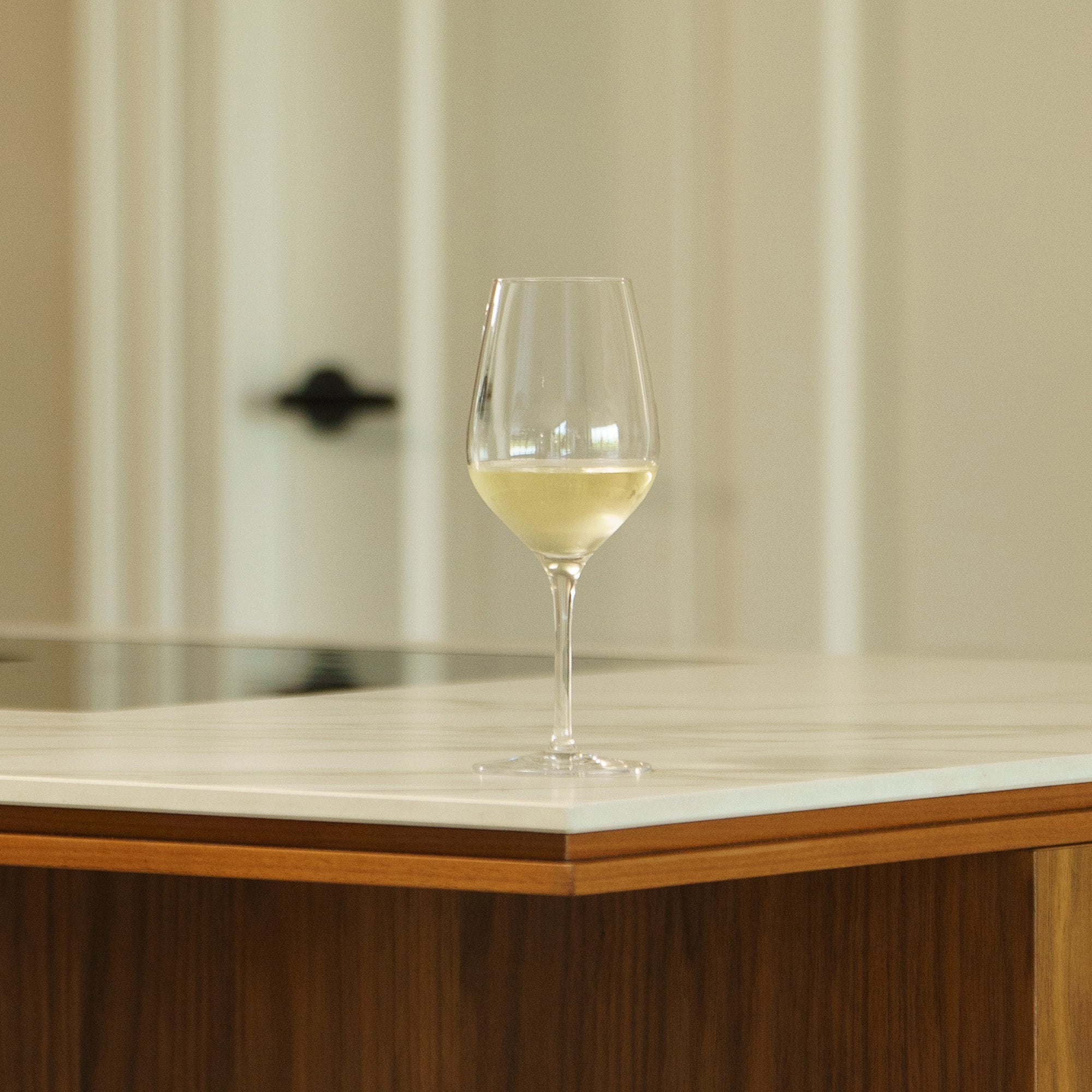 Hochwertige Weißweinkelche auf einem eleganten Küchentresen mit hellem Hintergrund