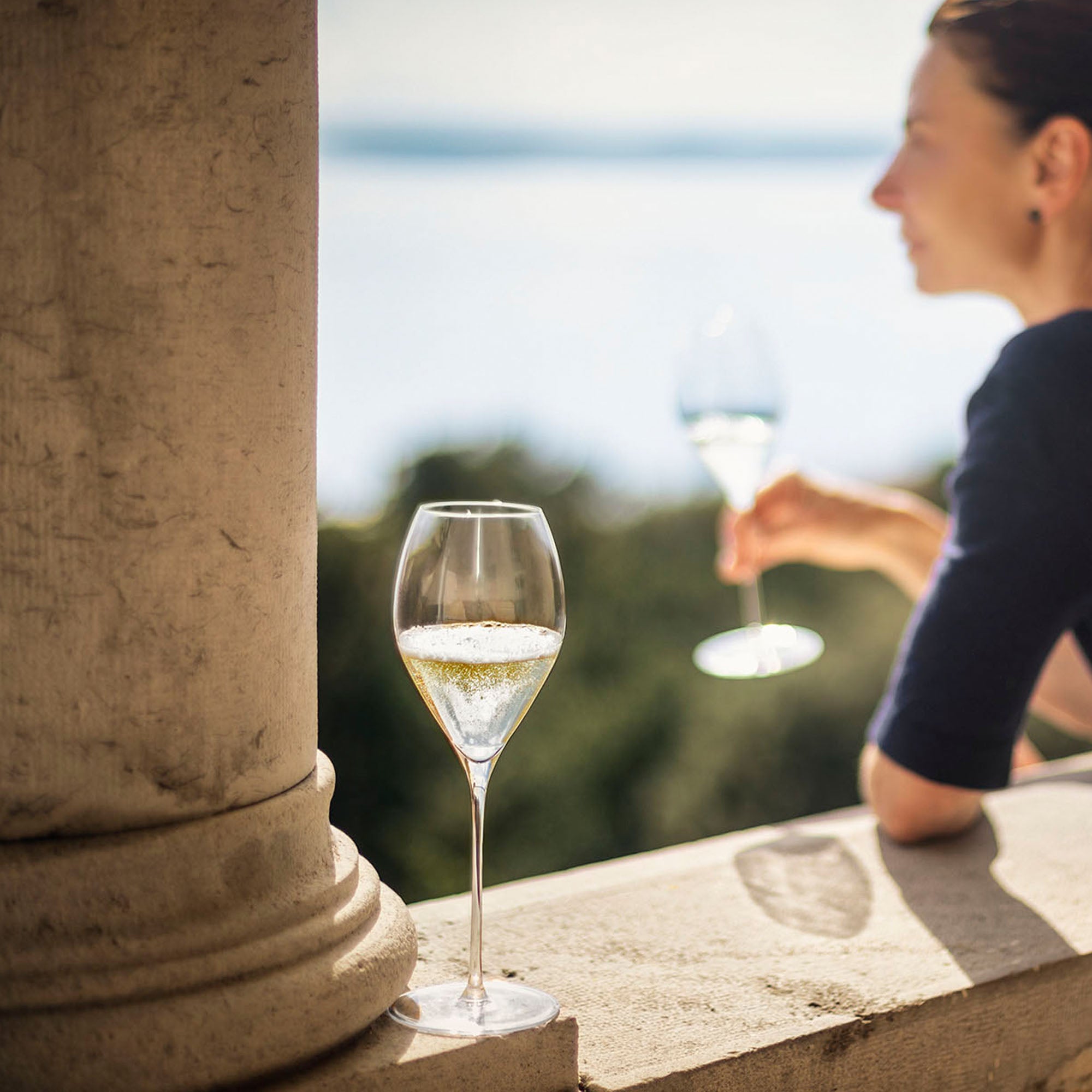 Hochwertige Sektgläser Stölzle auf einer eleganten Terrasse mit Blick auf den See