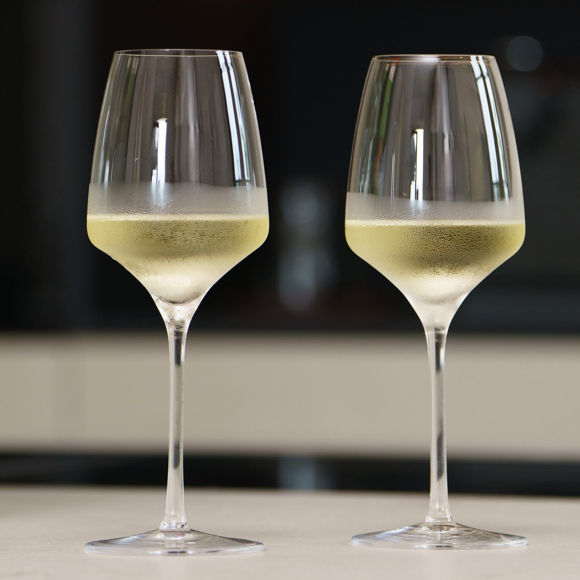 Zwei elegante, langlebige Weißweingläser auf einem Tisch, ideal für besondere Anlässe