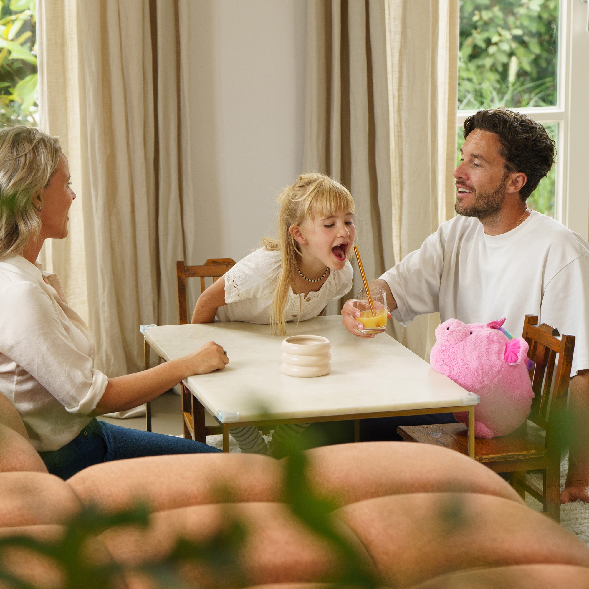 Familie genießt Getränke mit dem Mix-Drink Becher Set in einem hellen Wohnzimmer