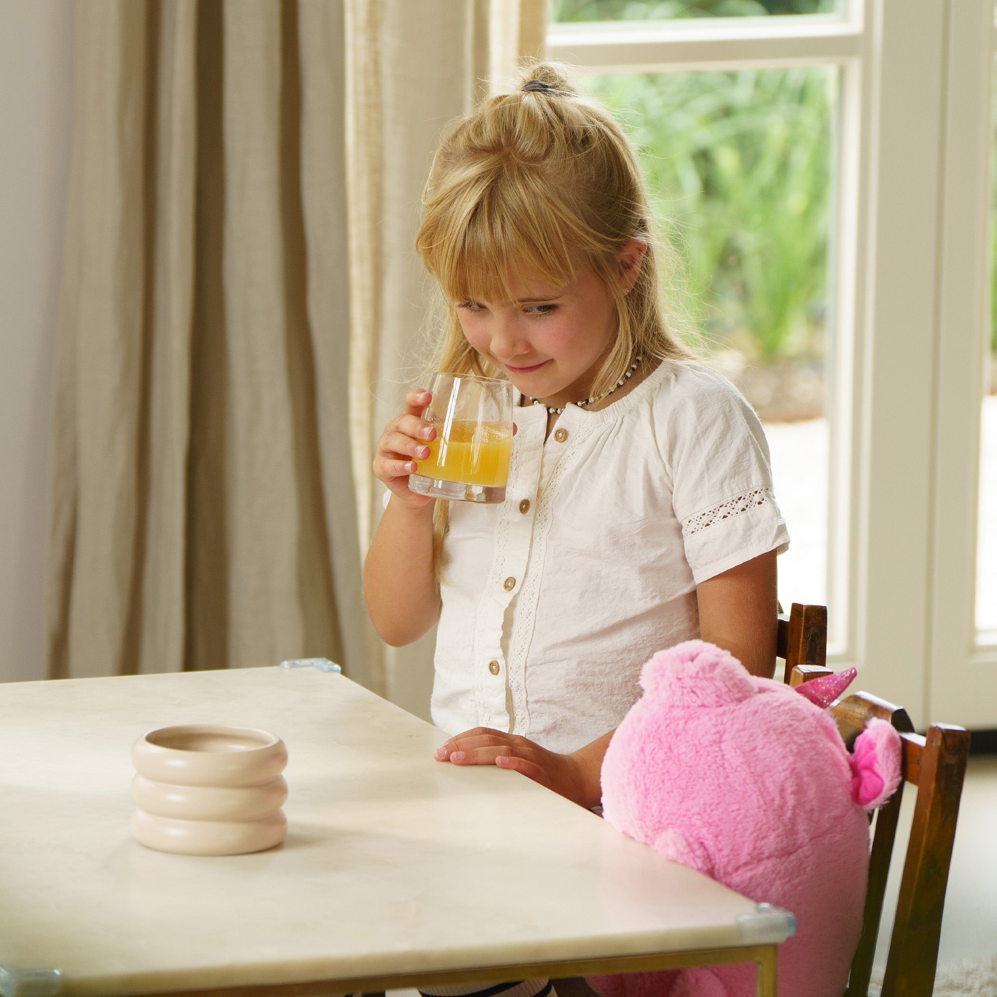 Mädchen mit Mix-Drink Becher Set am Tisch, trinkt ein erfrischendes Getränk im Glas