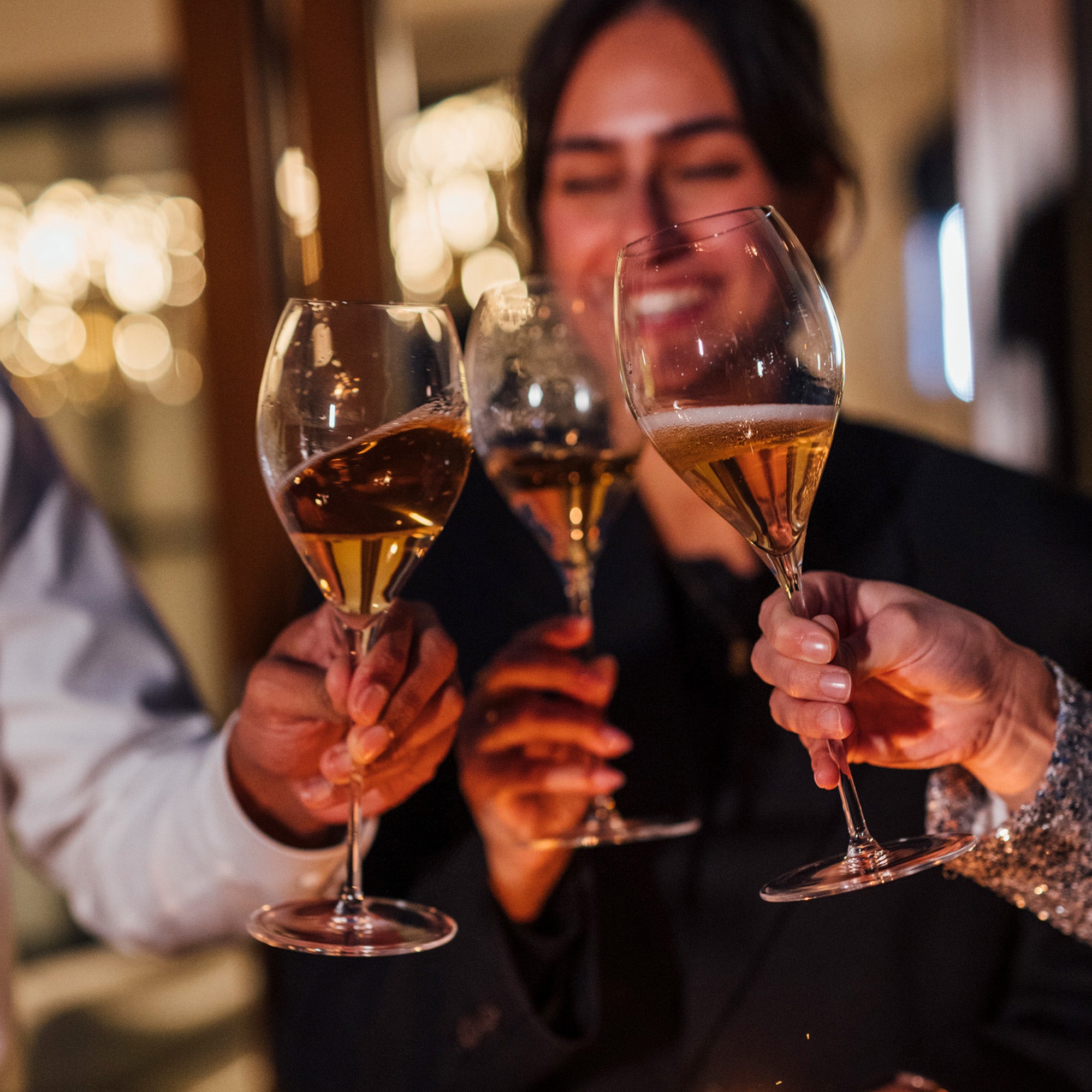 Stölzle Lausitz Sektgläser hochwertig mit goldenem Sekt gefüllt beim Anstoßen in geselliger Runde