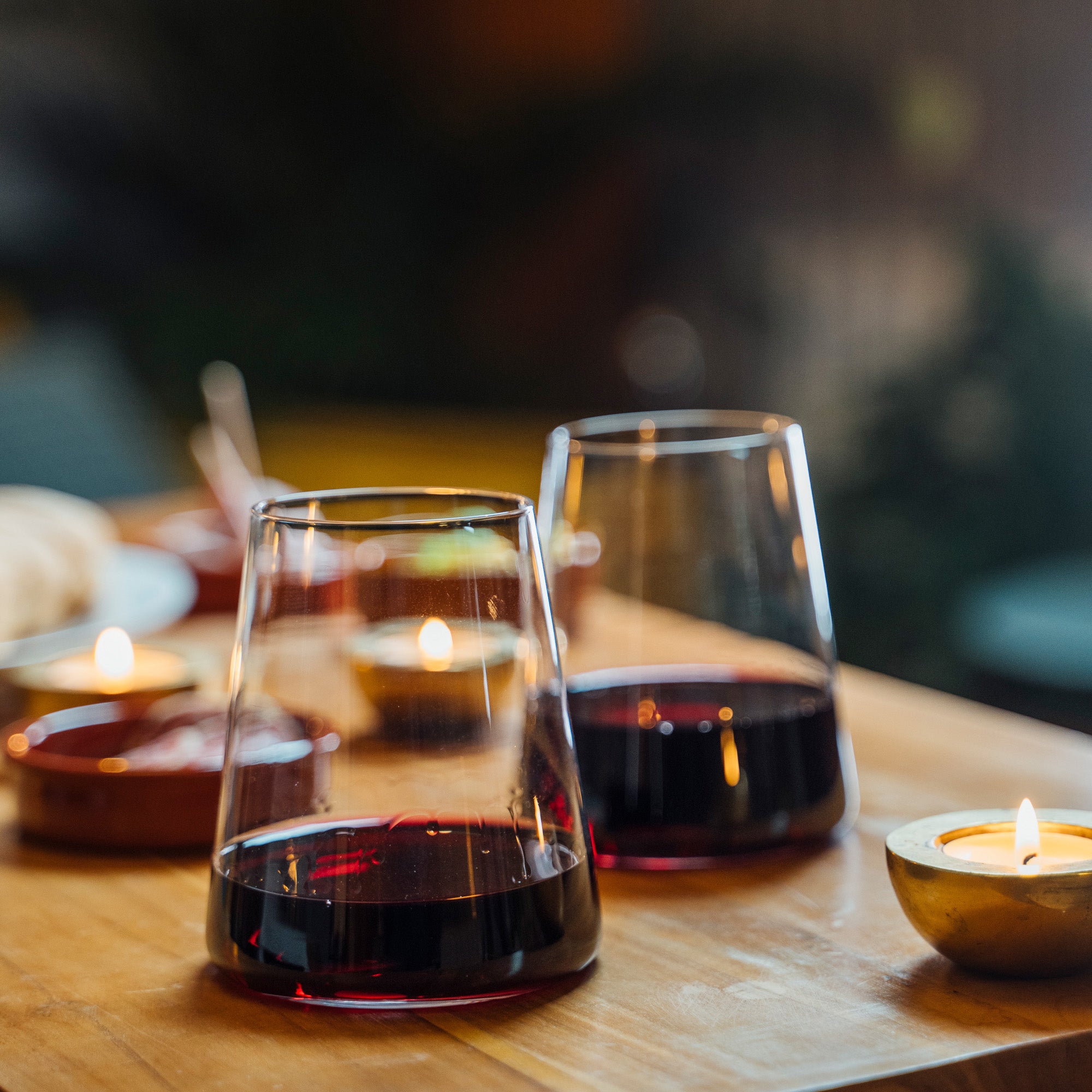 Stölzle Lausitz Power Rotweingläser auf einem Holztisch mit roten Wein und Kerzenlicht