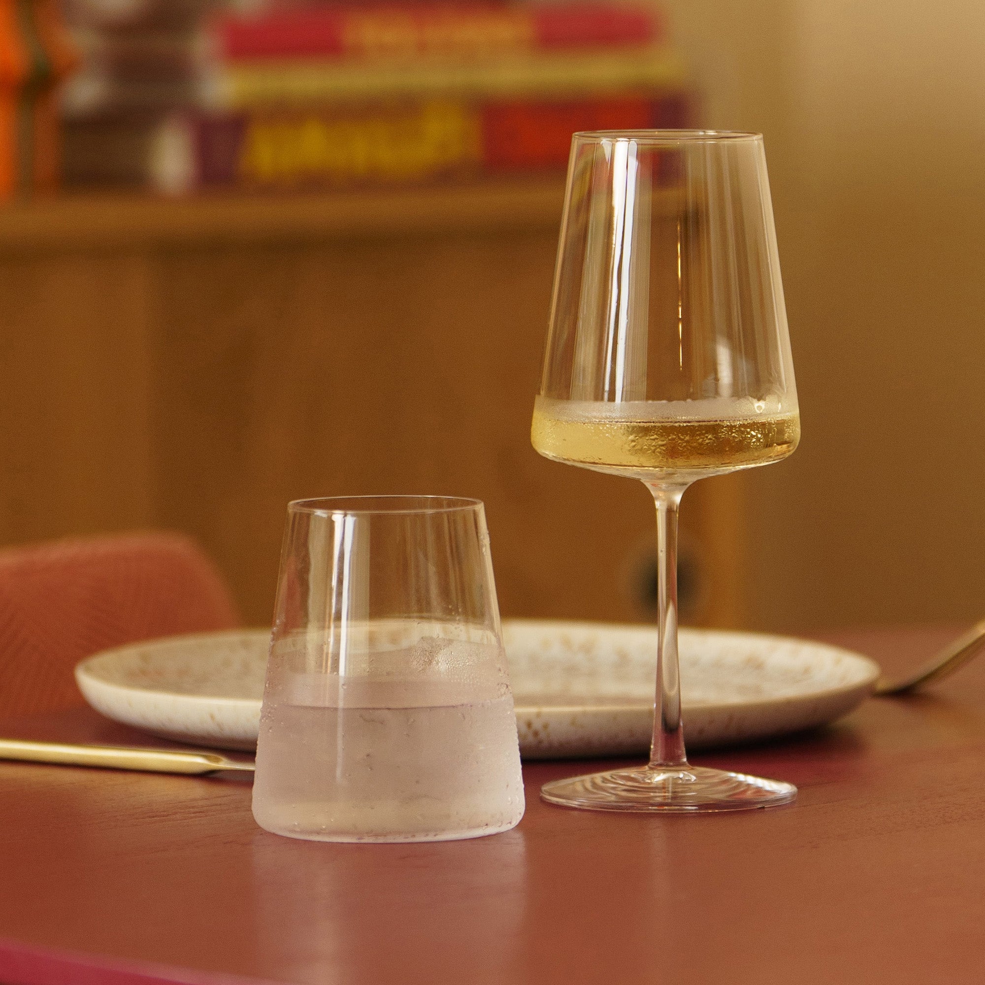 Stölzle Lausitz Weißweinkelche elegant mit goldfarbenem Wein auf einem Tisch neben einem Wasserglas