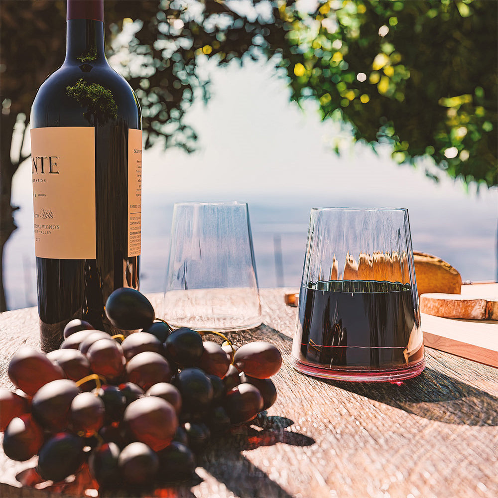 Stölzle Lausitz Weingläser für Rotwein kaufen, elegant auf einem Holztisch mit einer Weinflasche und Trauben