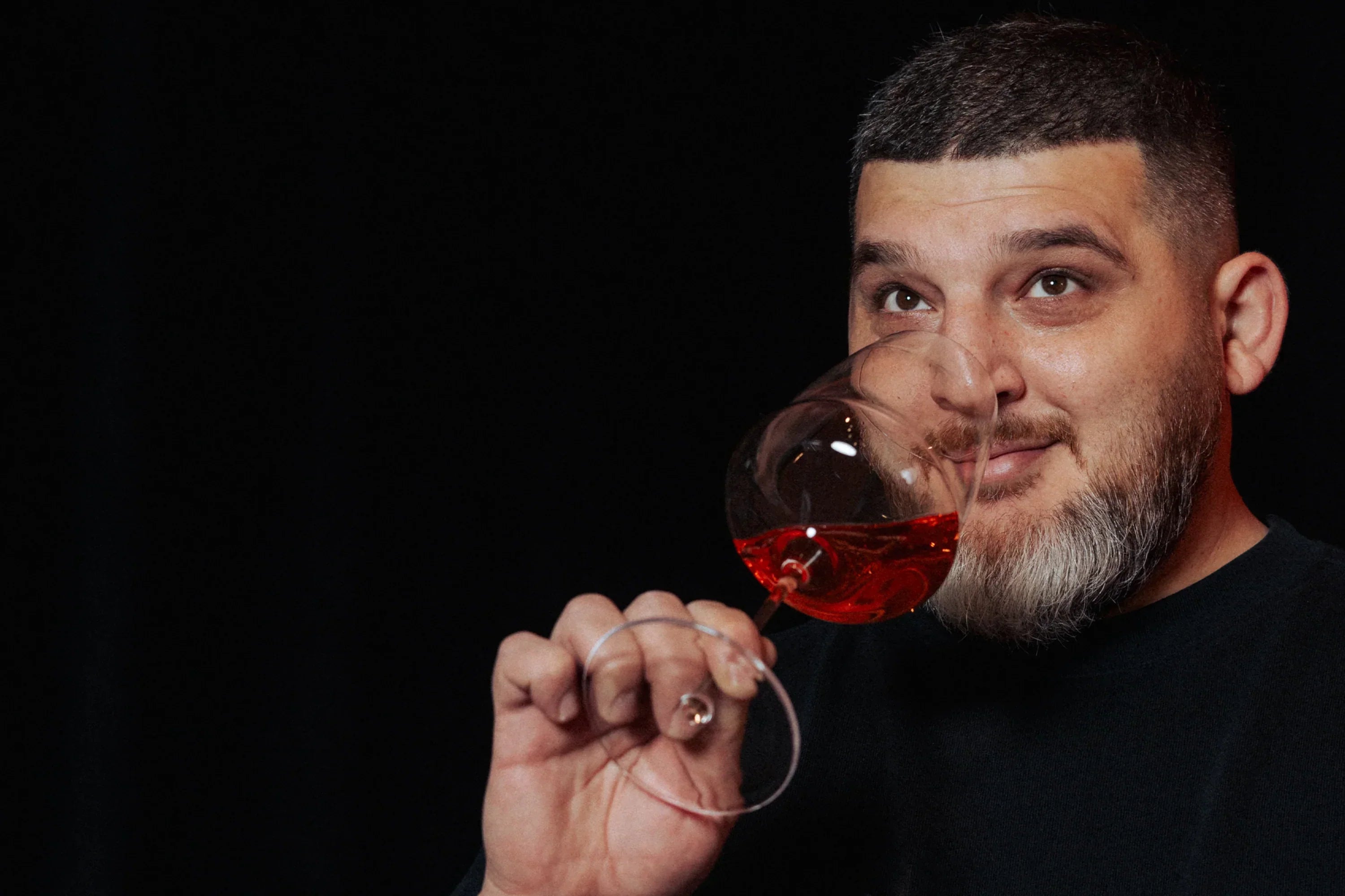 Tony D trinkt Wein aus einem Glas der Serie Cocoon