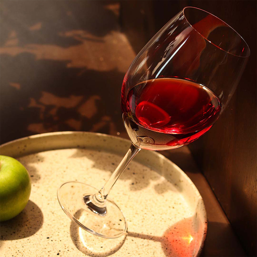 Elegantes Bordeauxgläser Set mit einem Glas voll Rotwein auf einem eleganten Tisch