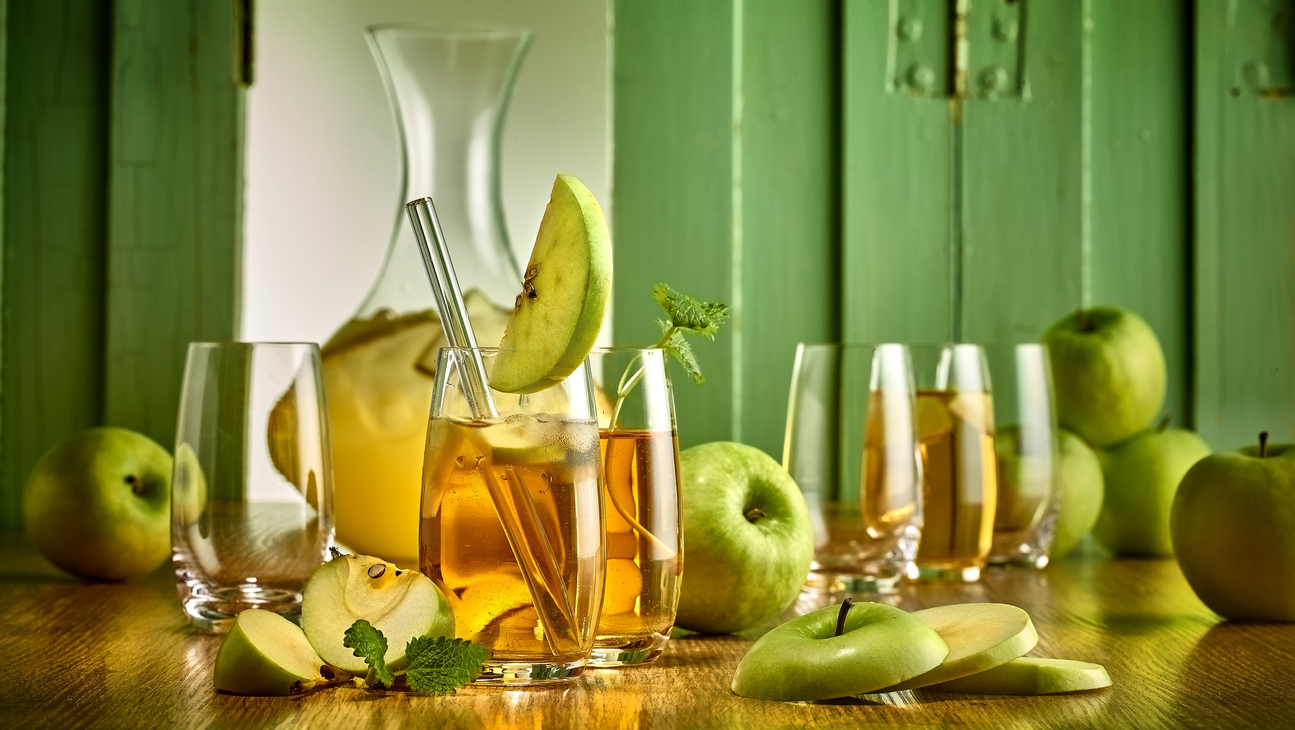 Stölzle Lausitz Gläser für Saft mit frischem Apfelsaft und grünem Obst auf Holztisch