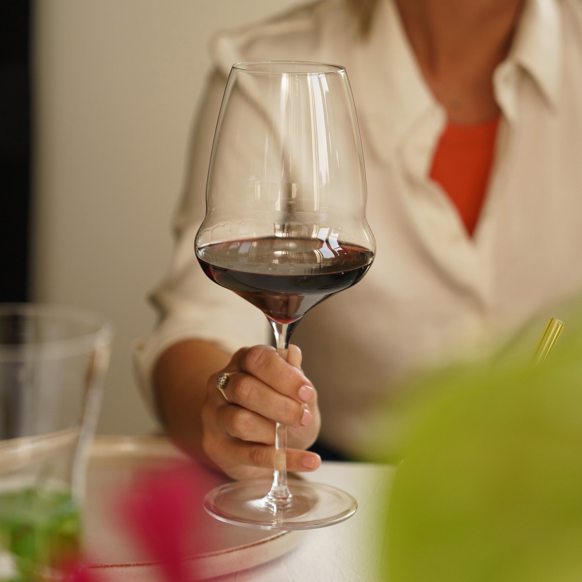 Elegantes Stölzle Lausitz Bordeaux Glas in der Hand mit vollem Rotwein für genussvolle Abende