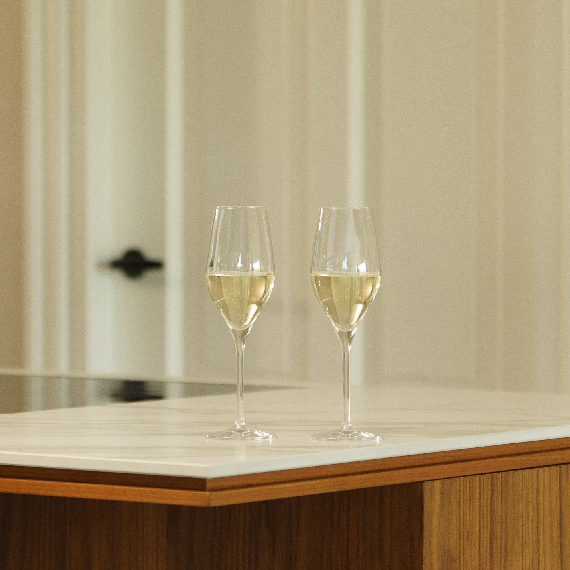 Zwei hochwertige Champagnergläser auf einer eleganten Küchentheke mit sprudelndem Champagne