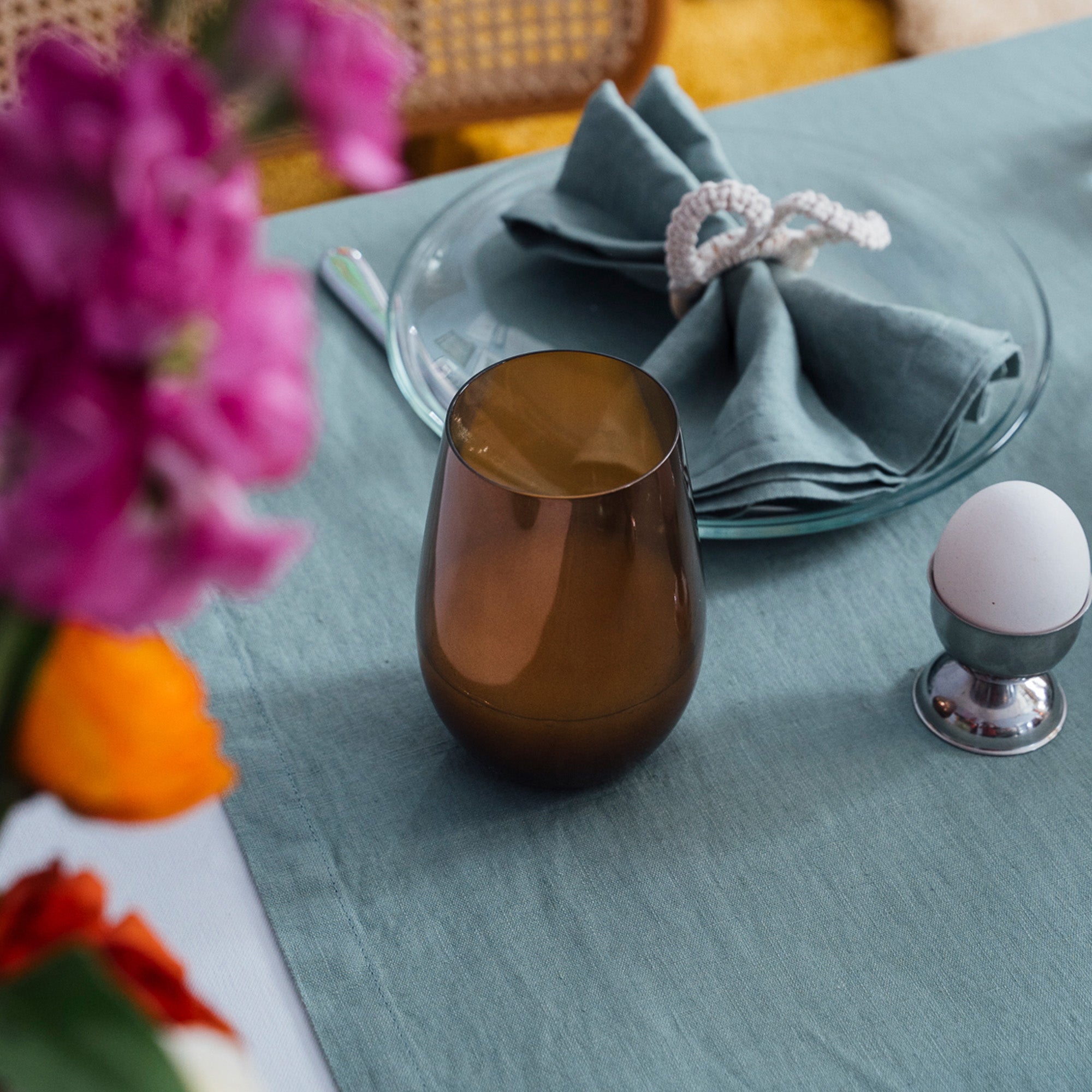 Braunes Longdrinkbecher Set braun auf einem Tisch mit Geschirr und Blumen im Hintergrund
