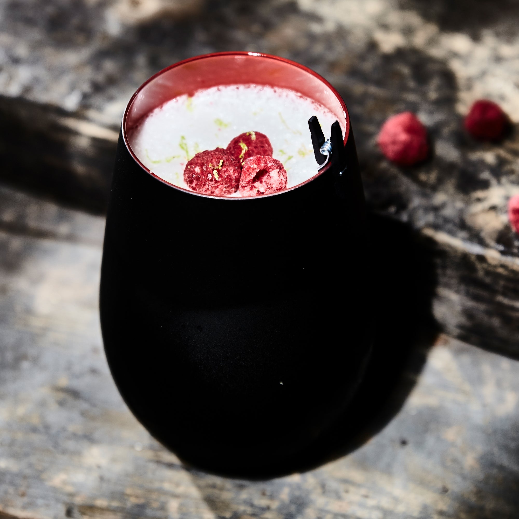 Schwarz Rot Elements Becher mit kreativer Dekoration und Fruchtstücken auf einem Holztisch