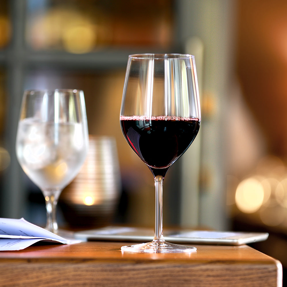 Eleganter Stölzle Lausitz Rotweinkelch mit intensivem Rotwein auf einem stilvollen Tisch