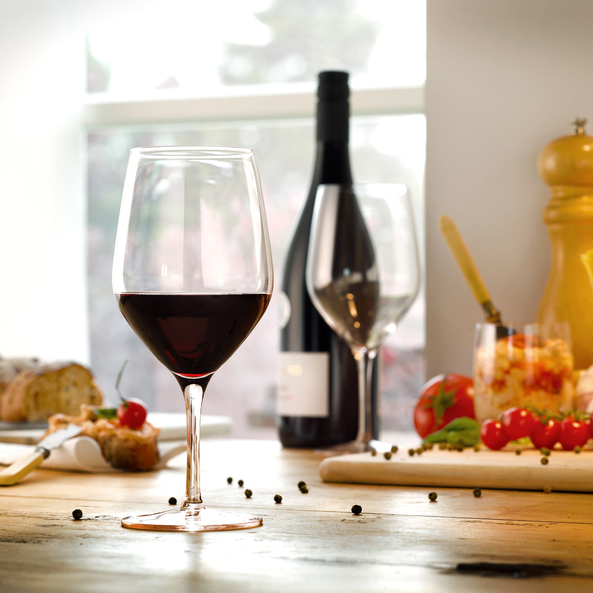 Eleganter Stölzle Lausitz Rotweinkelch mit vollem Rotwein auf einem stilvollen Tisch